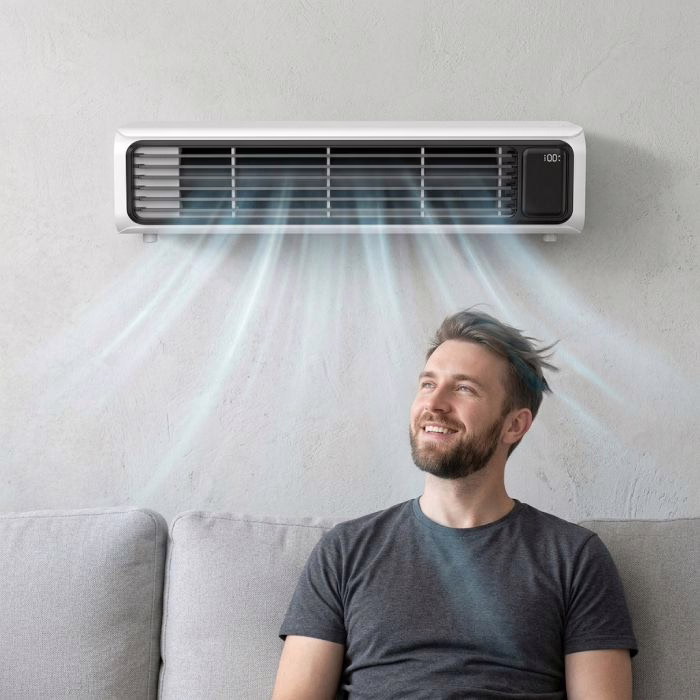 A man relaxing on a sofa in the airflow from a wall mounted FrostyLax cooler